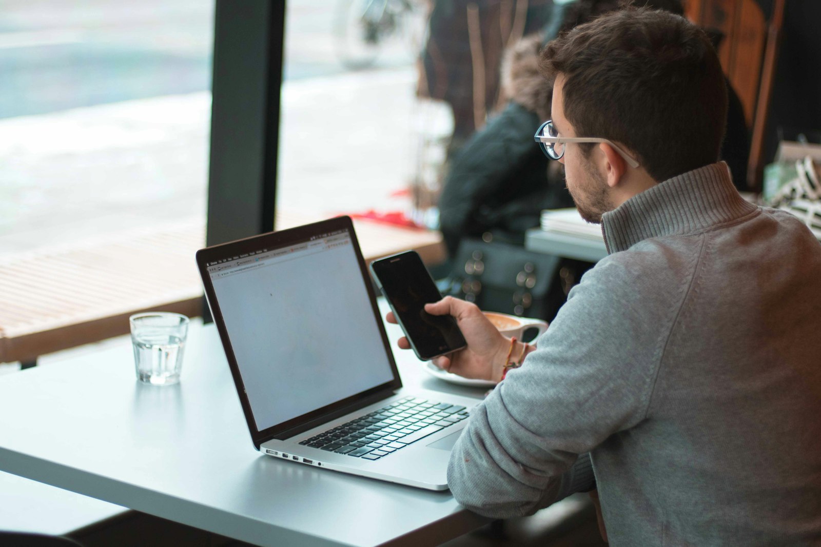Person using a tablet beside an open laptop