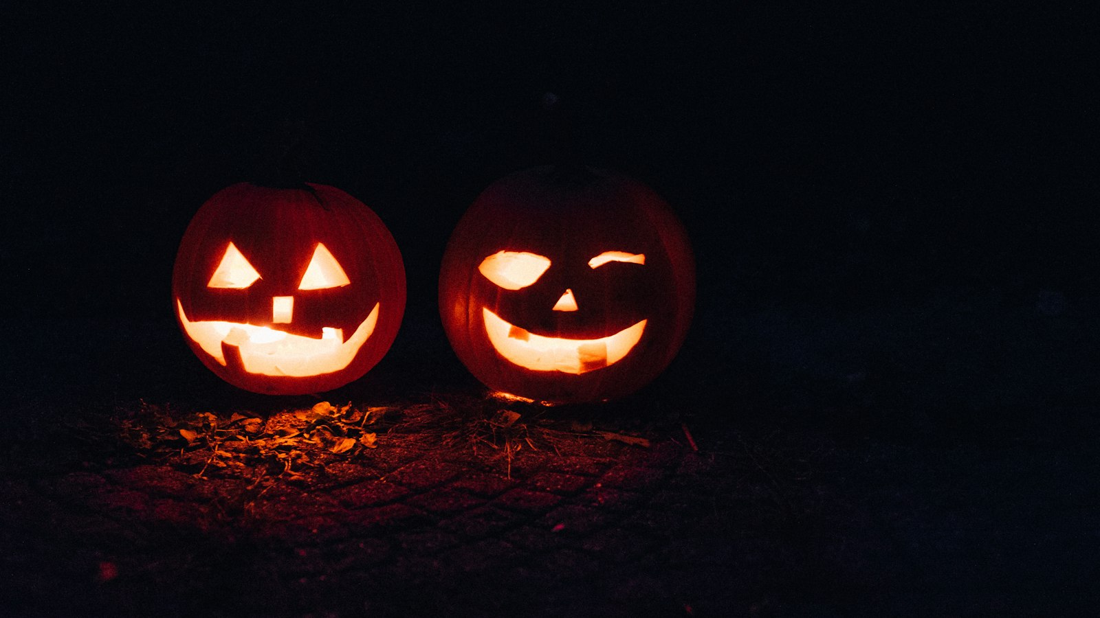 Two illuminated carved Halloween pumpkins