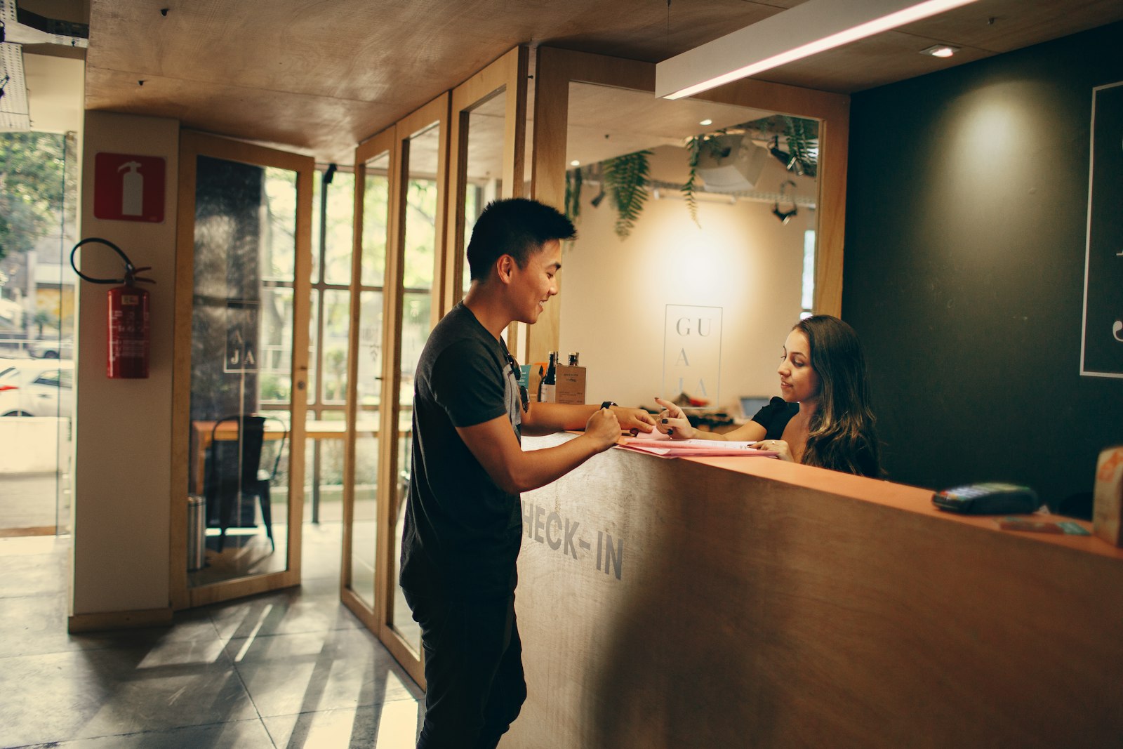 Guest speaking with an employee at a reception desk
