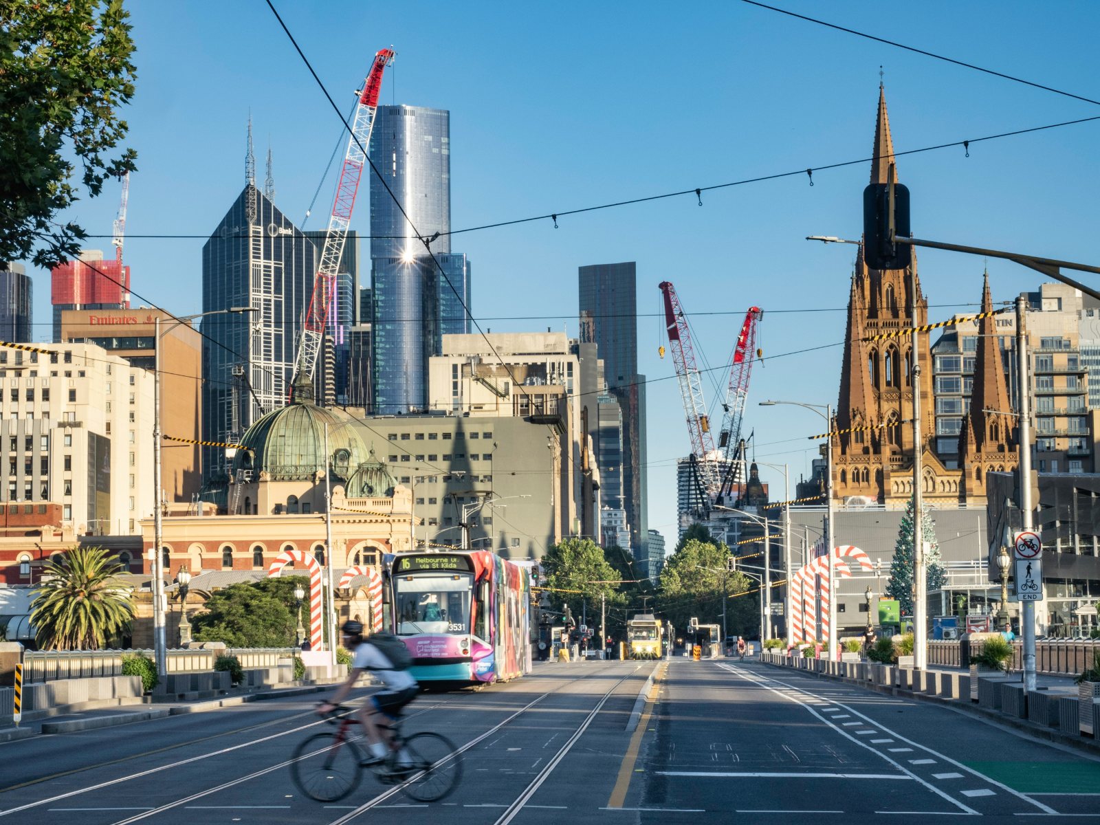 A tram and a cyclist on St Kilda Road in Melbourne in the early morning