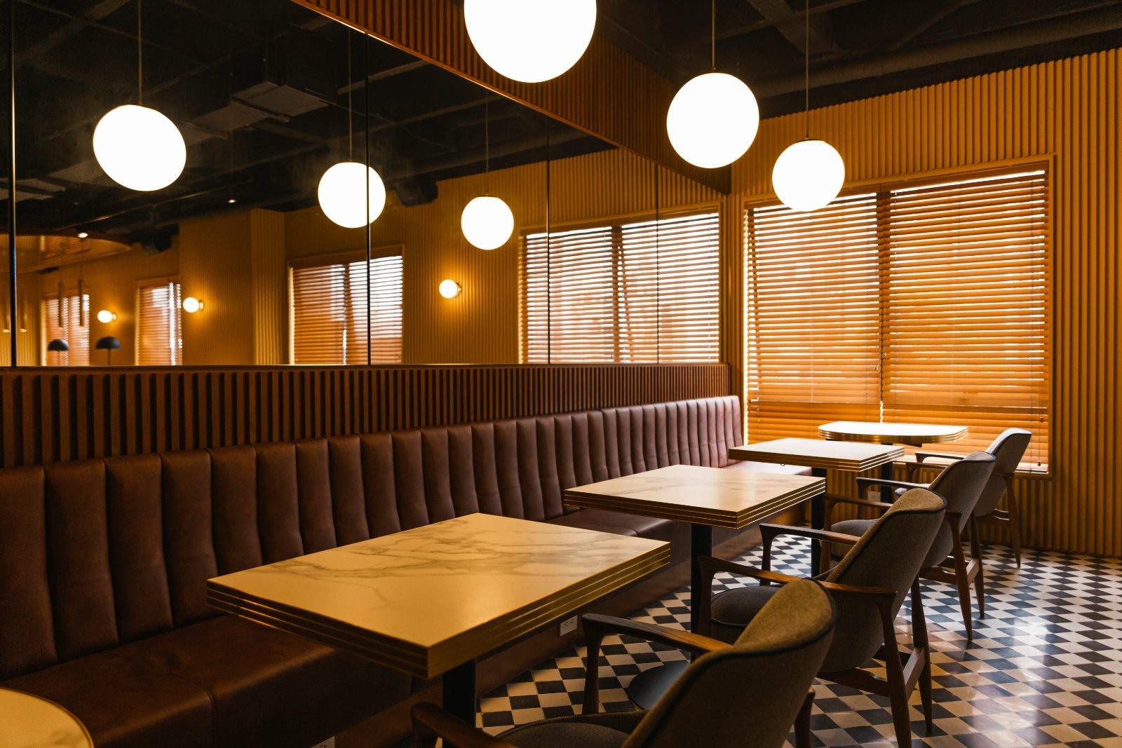A restaurant interior with a chequered floor and wooden booths